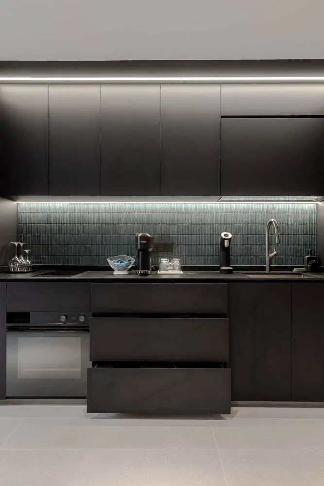 Turquoise KitKat-tile backsplash against matte-black cabinetry