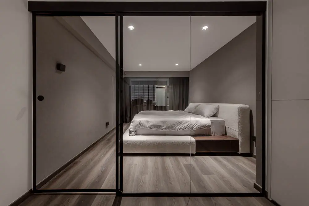 Master bedroom viewed through a glass sliding partition